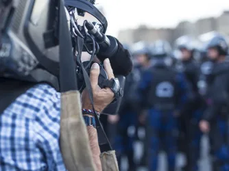 News cameraman films police on the streets